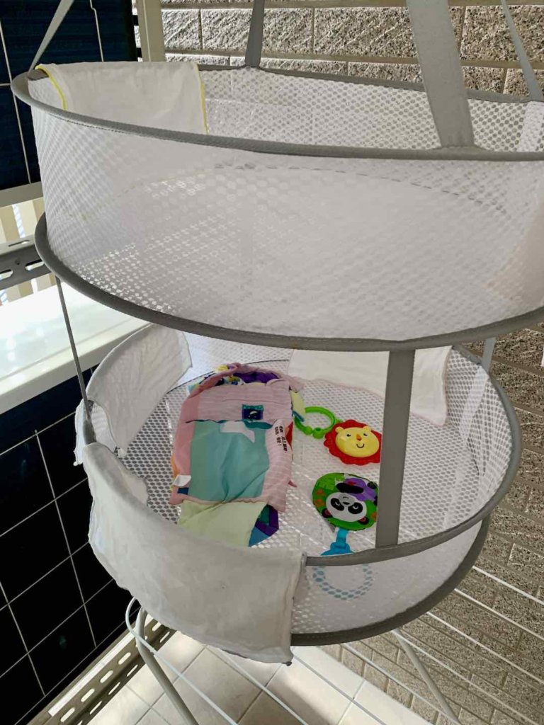 平面曬衣網，裡面有嬰兒口水巾和嬰兒玩具