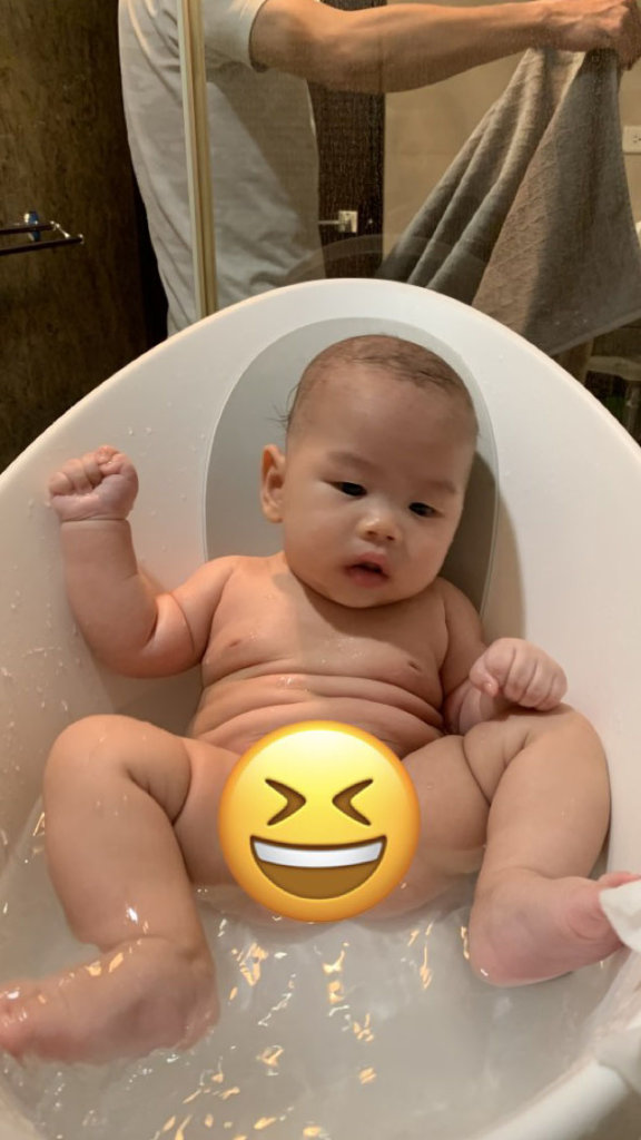 a baby taking bath in a shnuggle bathtub