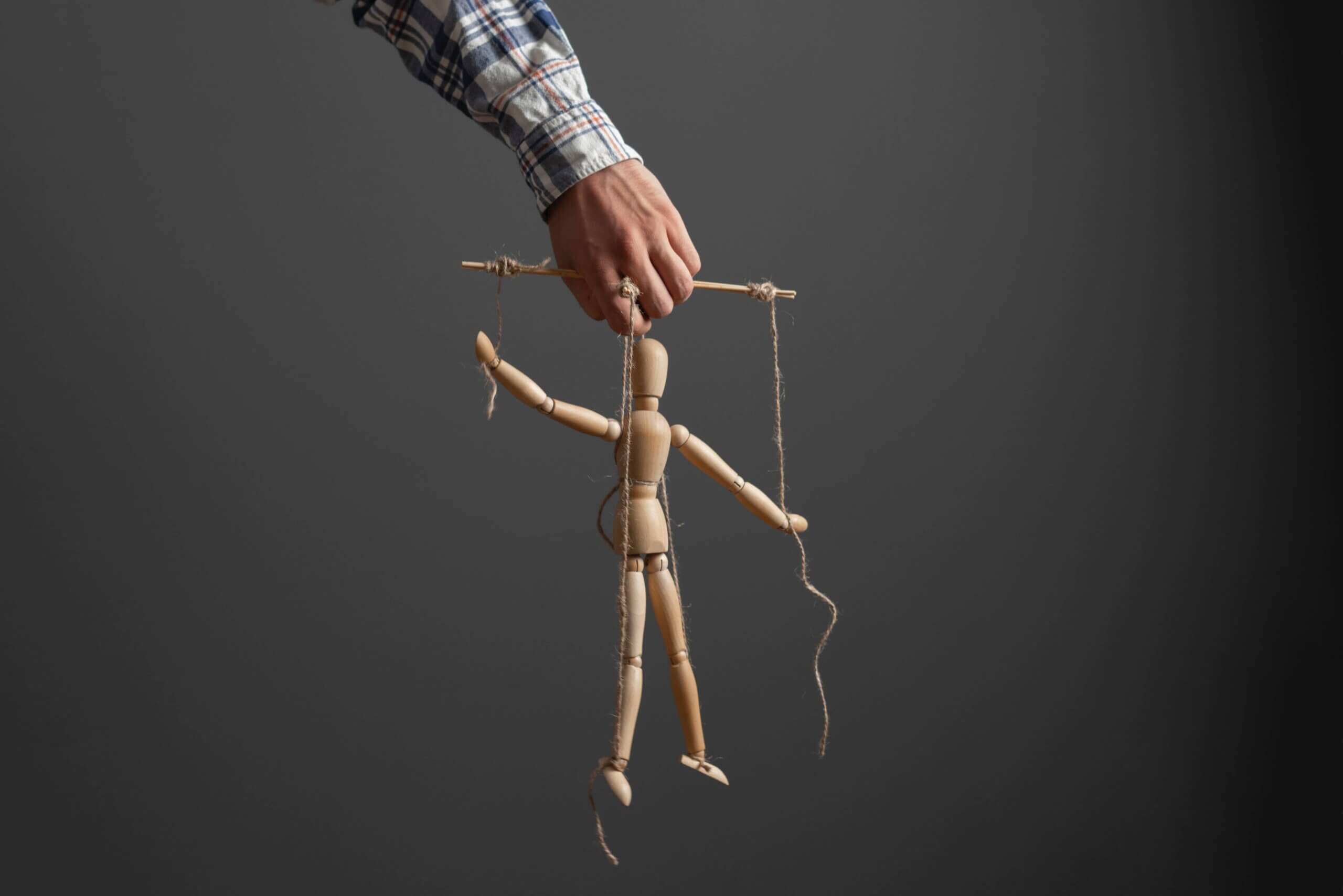 the emploee holding a marionette wooden doll, manipulation concept